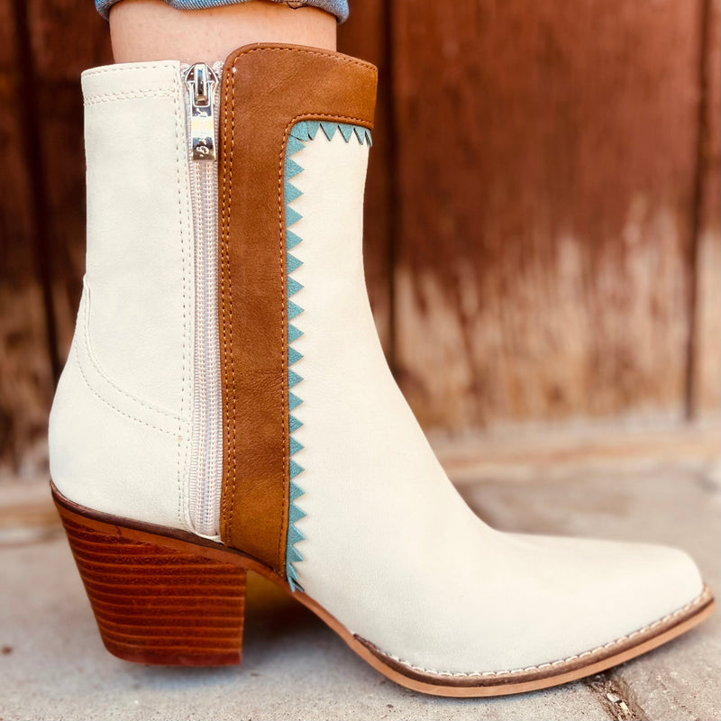 These Gizelle Aztec Tribal Fringe Boots are amazing in person. They are cream/nude colored with turquoise and brown leather accents. They have turquoise and silver flower conchos up the side with the brown fringe make these boots so beautiful. 9" tall boots with a 3" heel, these boots will dress up any skirt or pants.
