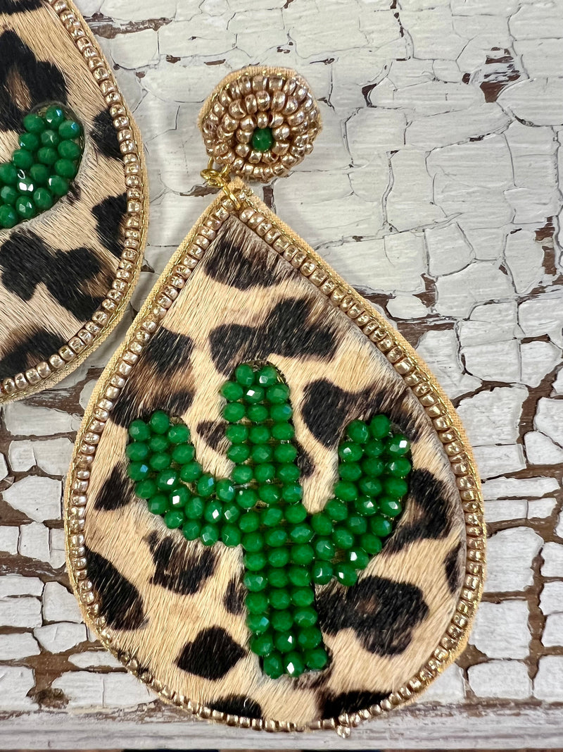 The Cactus in the Wild Water Drop Earrings are beautiful. The earrings are Leopard Hide with a green beaded Cactus inlayed.  The earrings are trimmed in gold beads with a beaded gold round post design. The earrings are 3 1/2" Water Drop Design.