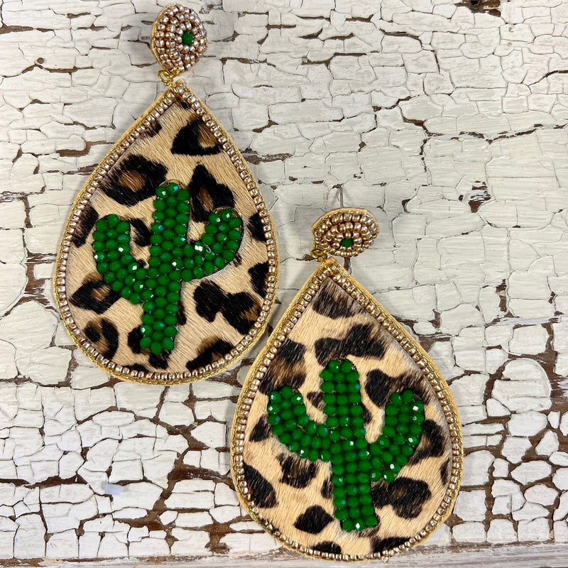 The Cactus in the Wild Water Drop Earrings are beautiful. The earrings are Leopard Hide with a green beaded Cactus inlayed.  The earrings are trimmed in gold beads with a beaded gold round post design. The earrings are 3 1/2" Water Drop Design.