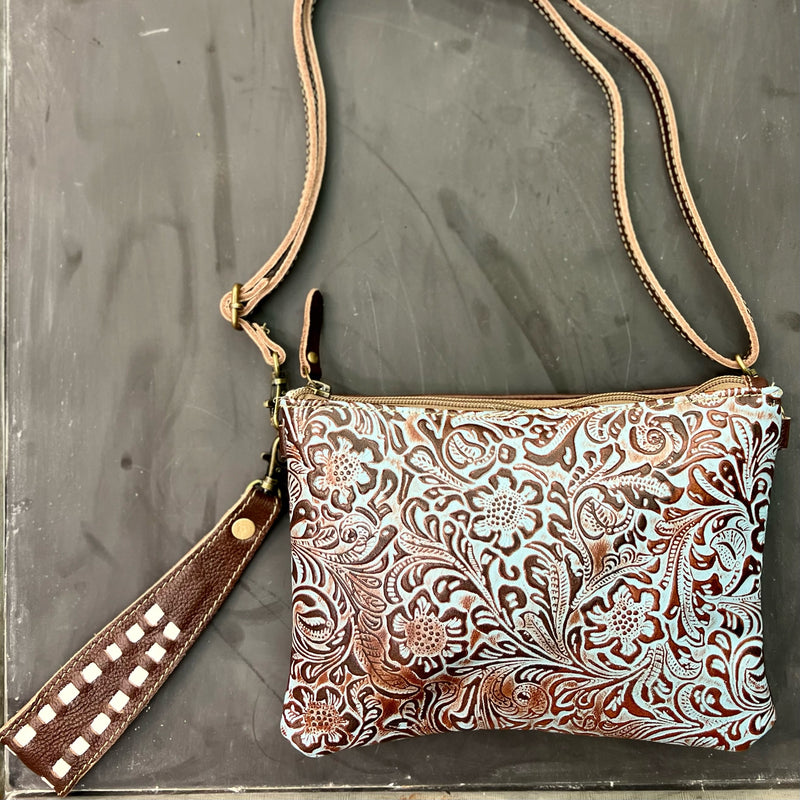 MADE BY MYRA HANDBAGS  The Floral Beryl Crossbody Wristlet is  a Dark Brown and Turquoise Tooled Leather Wristlet. The bag features a 7" adjustable/removable wristlet strap or a 24" removable/adjustable crossbody strap. The bag features a top zipper closure.   Dimensions: 9.5" W X 7" H