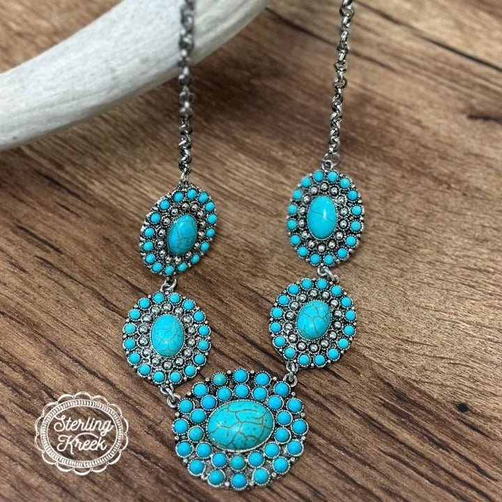 Feel like royalty with THE MERRYWEATHER NECKLACE! Five turquoise chonchos dangle playfully on a silver chain, making it the perfect accessory for any occasion. Slip it around your neck and let the compliments fly - it'll be the life of any party!   MATERIAL : Alloy,Turquoise  LENGTH: 11"