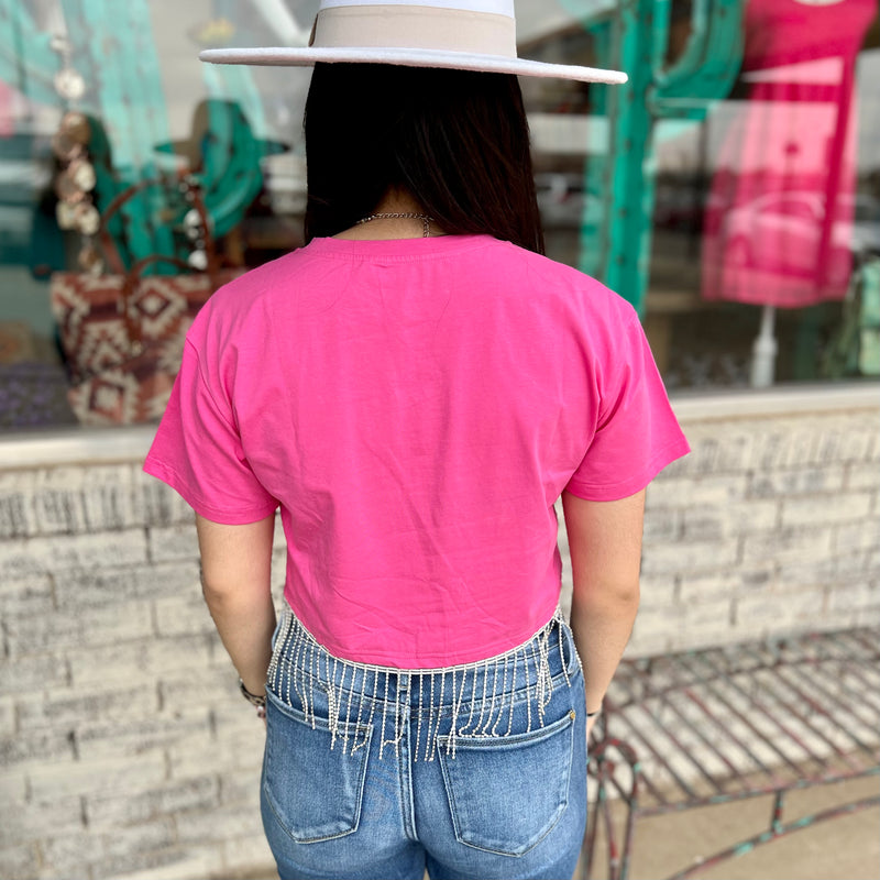 This stylish pink crop top is crafted from soft cotton fabric and designed with an eye-catching rhinestone fringe for maximum sparkle. The short sleeve design is perfect for hot summer days and adds a touch of glamour.  Material: 95% Cotton, 5% Elastane