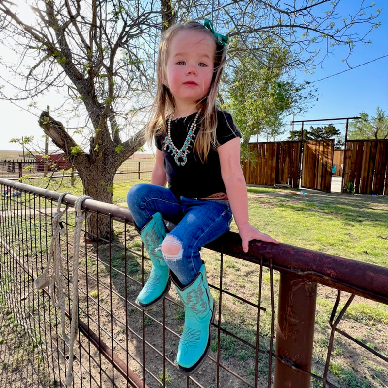 By Tanner Mark  For your little rodeo princess! Toddler sized turquoise leather boots. Midcalf shaft height, square toe.