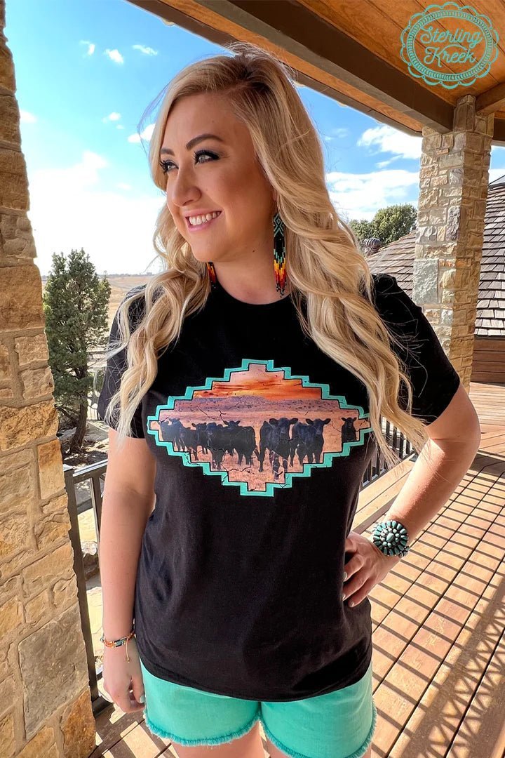 No need to round up the herd, they've come to you! Show your cowboy spirit in this Home Is Where The Herd Is Tee! Featuring a beautiful Aztec picture of calves in a vibrant sunset, it's the perfect way to declare your ranching pride with a cozy, stylish twist. Home is indeed where the herd is!   90% COTTON 10% POLYESTER