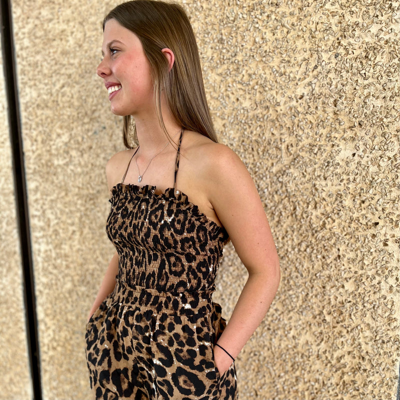 Glam up your wardrobe with the Back of the Leopard Jumpsuit! This daring piece features a halter neck, smocked bust and a strappy backless silhouette for an effortlessly edgy look. Go bold and unleash your wild side with an elastic fit that will have you feeling trendy and confident. Show who's boss and dominate the street in this show-stopping jumpsuit!