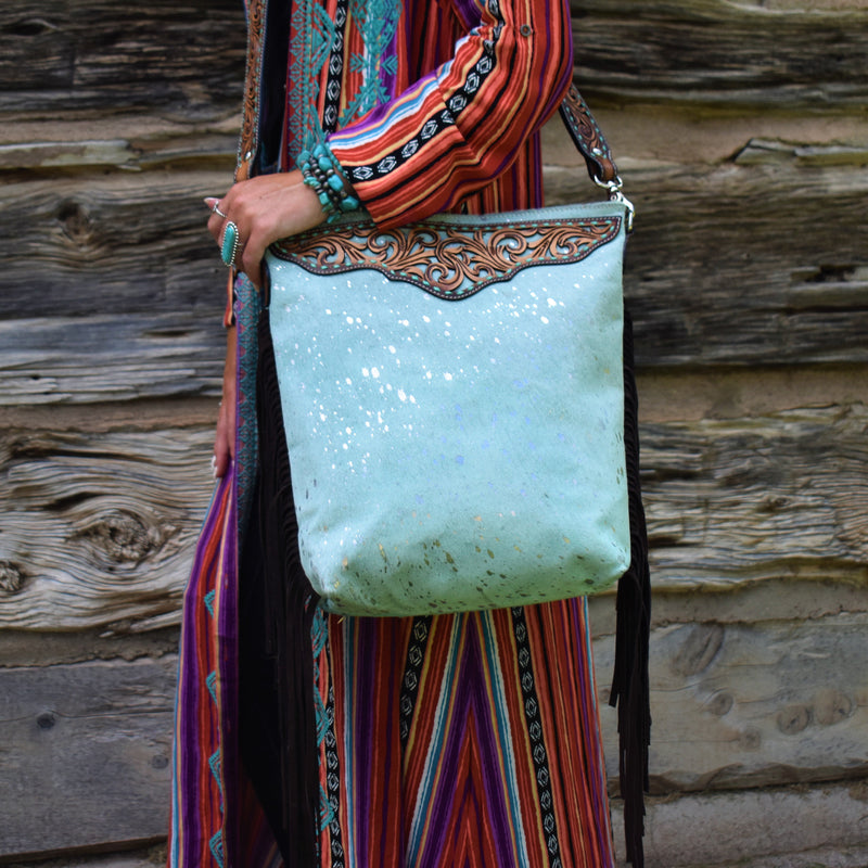"Mint colored hair on hide acid splashed concealed carry crossbody bag with a tooled accent strip across top front border.  Has a tooled leather and mint colored strap with mint stitching. Top zipper closure with concealed carry pocket on the back.   15 1/2"L  x 13   48" strap
